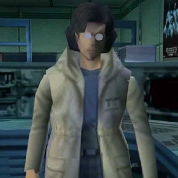 A young man with dark neck-length hair, circular glasses, and a white coat with a blue shirt underneath.